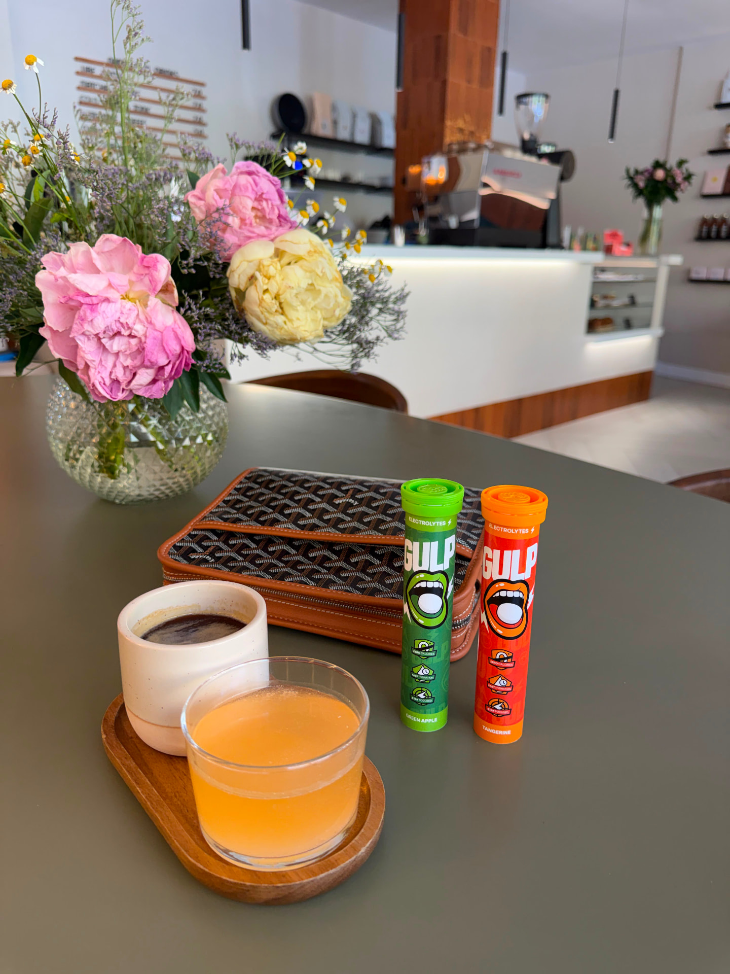 Green apple and tangerine GULP tubes on a café counter