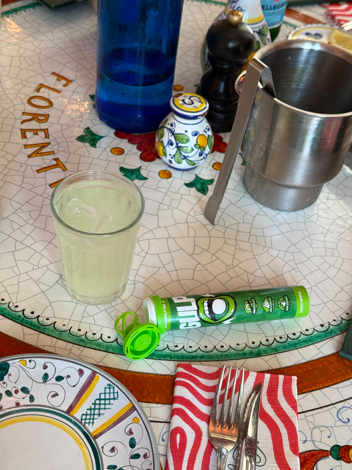 GULP green apple tube beside a chilled drink on a mosaic table